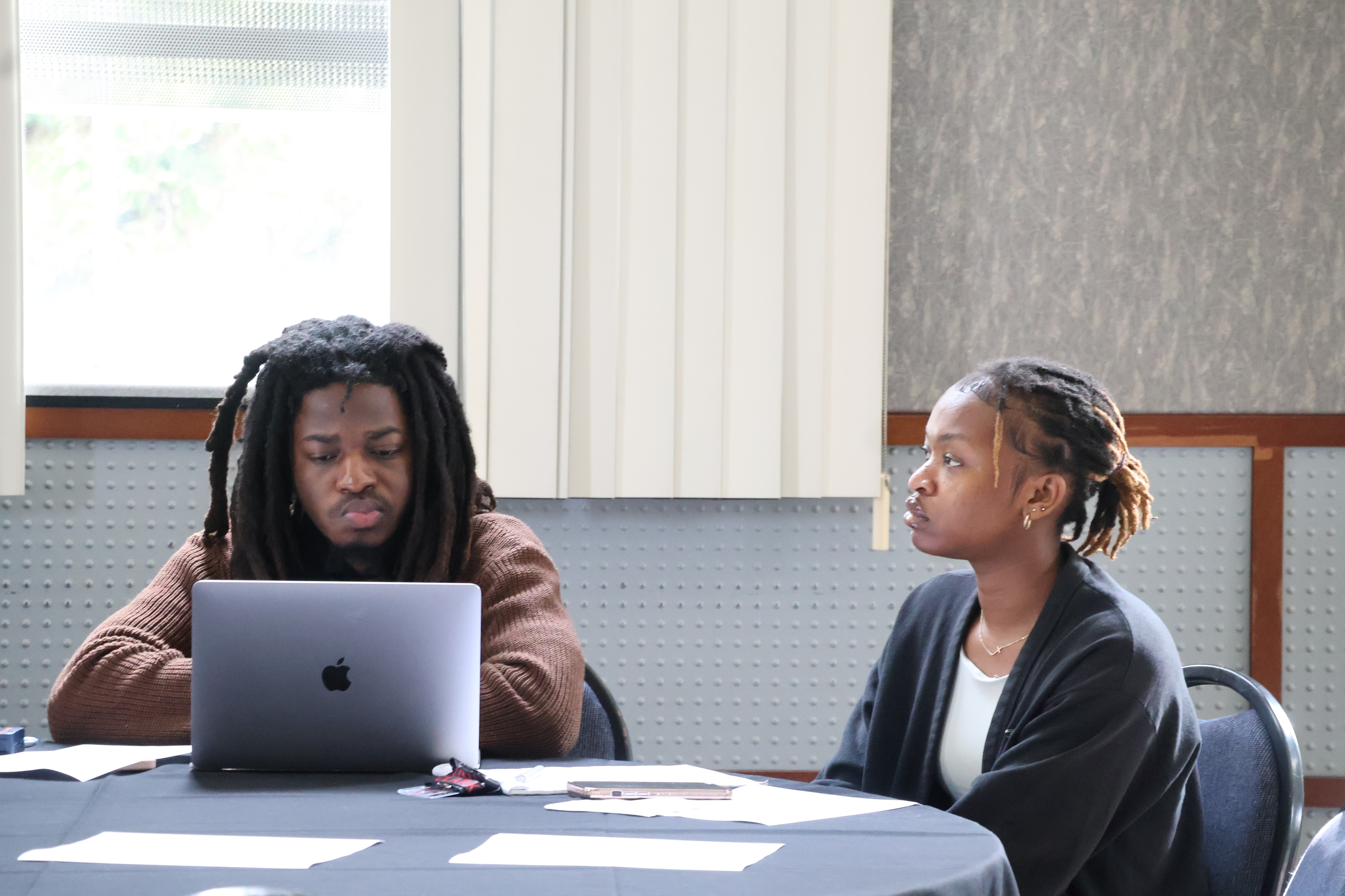 Two members of the program's early cohorts listen in as George discusses future growth.